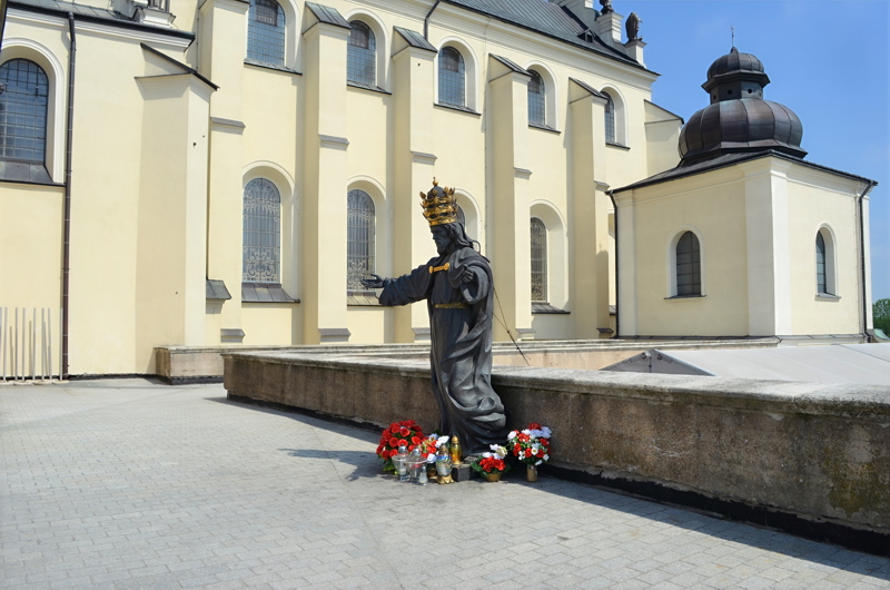 3 - A dark metal statue of Christ the King wearing a prominent crown, standing atop the roof area near the Cenacle at the Jasna Góra Monastery in Częstochowa, Poland